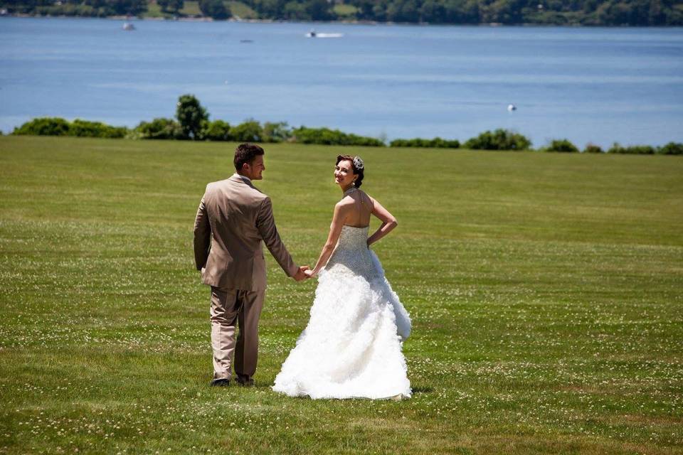 Newlyweds walking across the grass