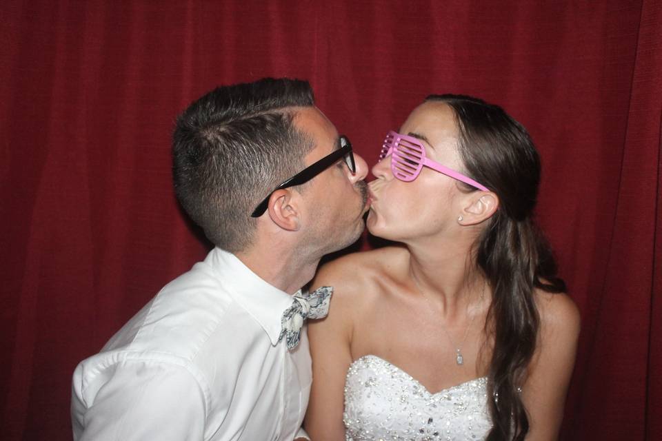 Newlyweds kissing in the booth