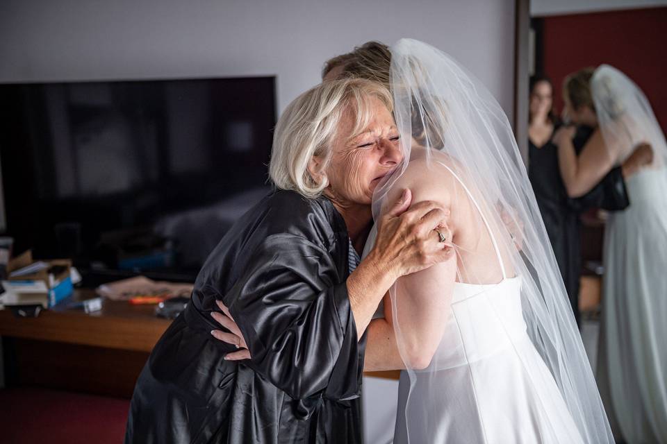 Mom and bride hugging