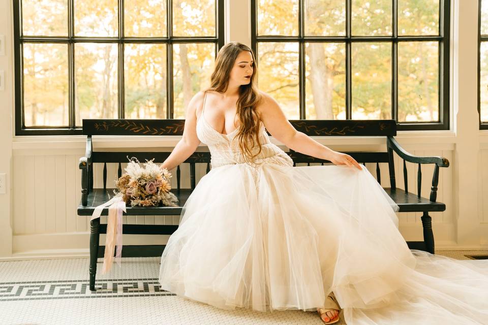 Bride on bench in sunroom