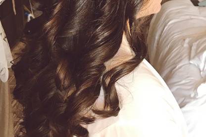 Curled half updo with floral accessory
