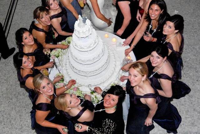 The bride with her bridesmaids at the wedding cake