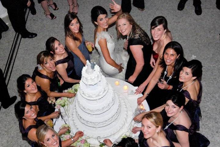 The bride with her bridesmaids at the wedding cake