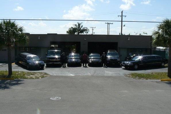 several sedans, limousines, van & Navigator in front of warehouse in Boca Raton