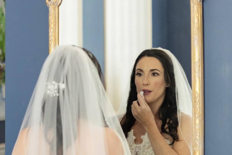 Bride applies lipstick