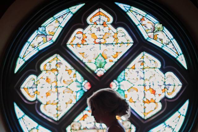 Bride beside stained glass window