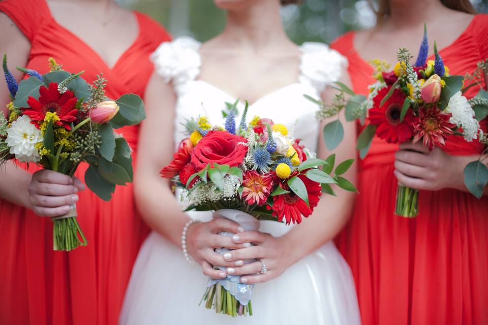 Rustic bridal bouquet for a poppy (red) and yellow wedding.  Hand tied bouquets consist of anemones, veronica, gerbera daisies, thistle, roses, eucalyptus, billy balls, and dahlias.