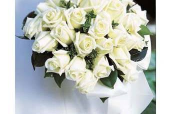 White roses in a nosegay with a satin bow for a simple elegant look.