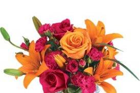 A glass cube filled orange roses, lilies. Also accompanied by hot pink roses and mini carnations