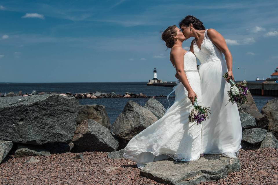 Brides kissing with lighthouse