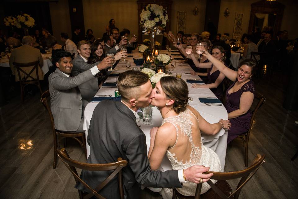 Couple kissing at head table