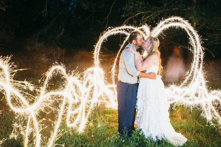 Newlyweds kissing with light painting in the background