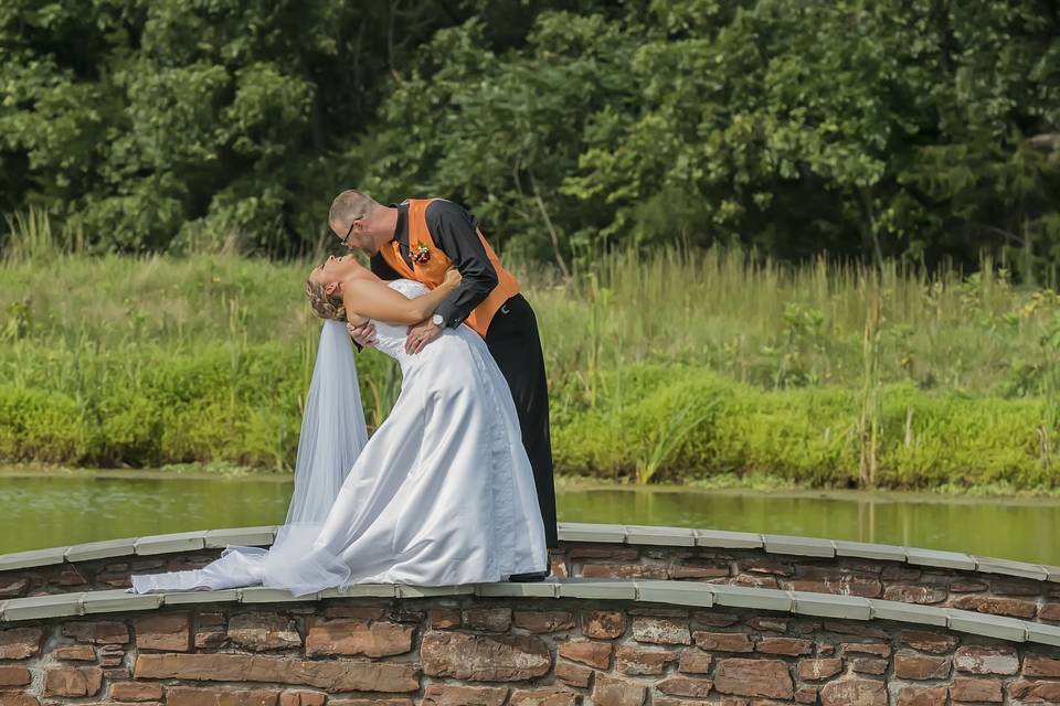 Andy dips his bride on a bridge at the Links in Gettysburg, PA. This image may not be reproduced without the expressed written consent of Donnie Dahlen Photography.