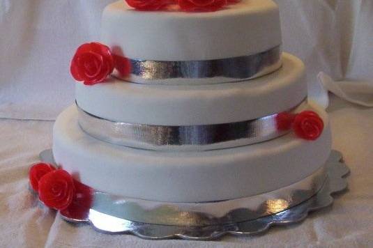 This is an example of a fondant cake with pulled sugar red roses. The silver decorations can easily be replaced with fondant or ribbon of a different color and the color of the roses can be changed as well.