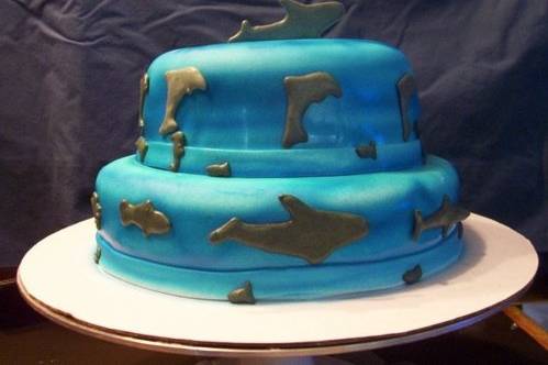 This cake is a cake for someone who is fond of the ocean and various sea creatures. The cake is covered in fondant and has been airbrushed a blue ocean color and the animals are made from piped royal icing and are grey to give a shadowy look. Nearly any kind of animal or object can be made using royal icing and it can result in a very nice look for your cake.
