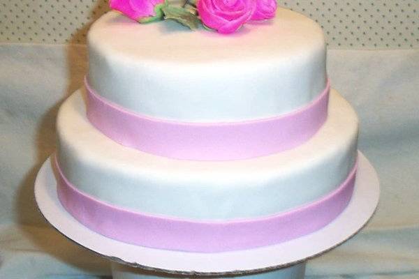 This is a white fondant cake with handmade gumpaste roses. The roses can be made in any color and the type of flower is the customers choice.