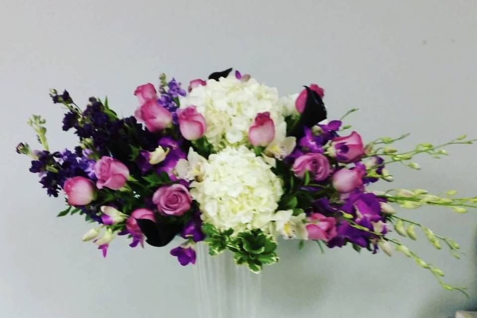 Tall centerpiece including roses, hydrangea, orchids, stock and calla lilies