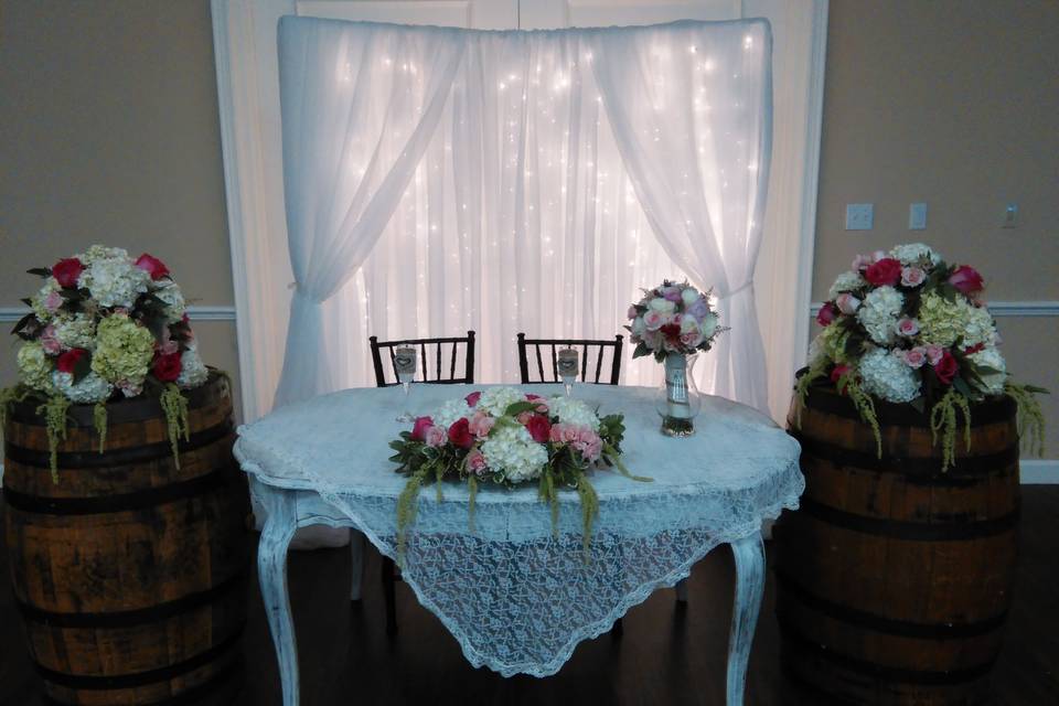 sweet heart table including roses, spray roses, eucalyptus, hydrangea and hanging amaranths