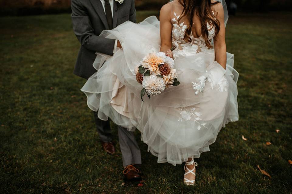 Groom holding brides dress
