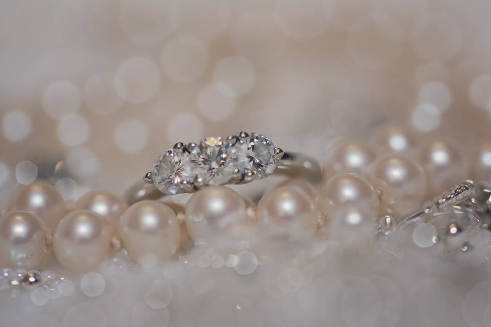 Photo of the bride's engagement ring along with the first piece of jewelry she ever received from her mom.