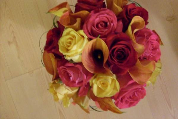 Bridal bouquet for tropical theme. Red, pink and yellow roses with mango calla lilies.