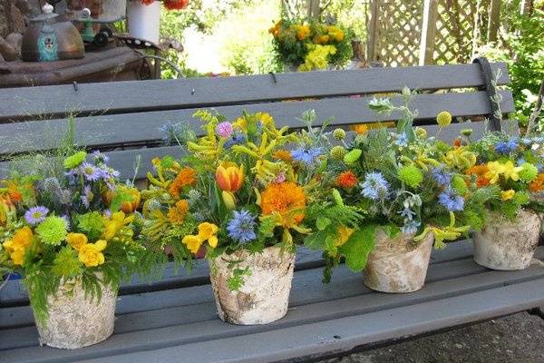 Wildflower arrangements in a birch wrapped vase.