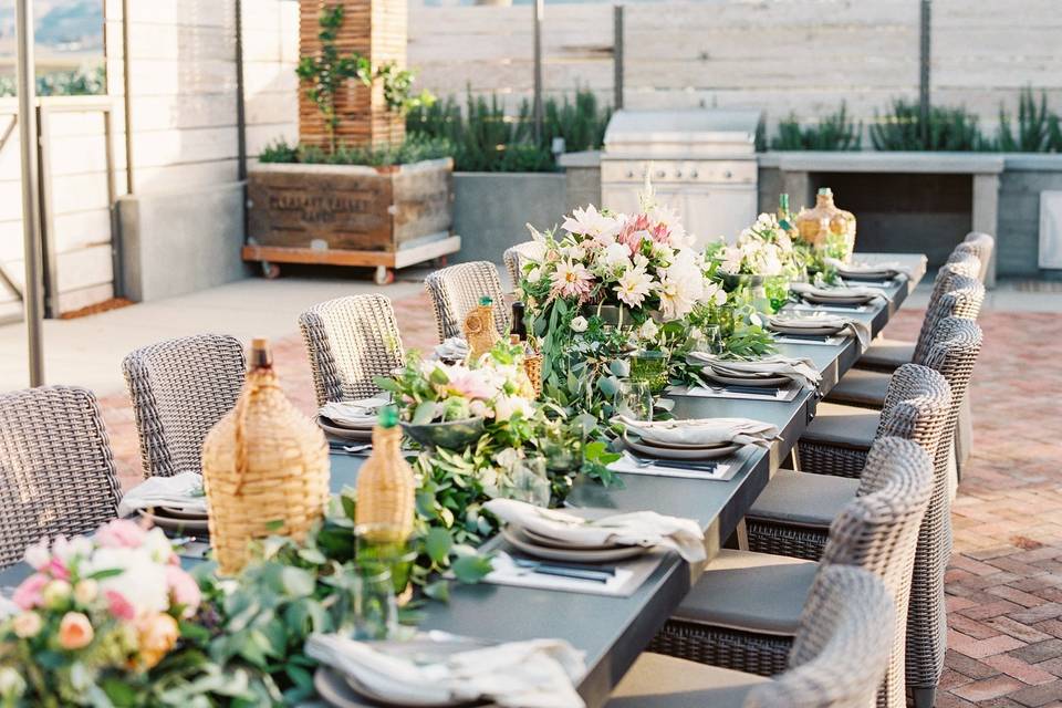 Garland greenery centerpiece with floral and wicker wine bottles