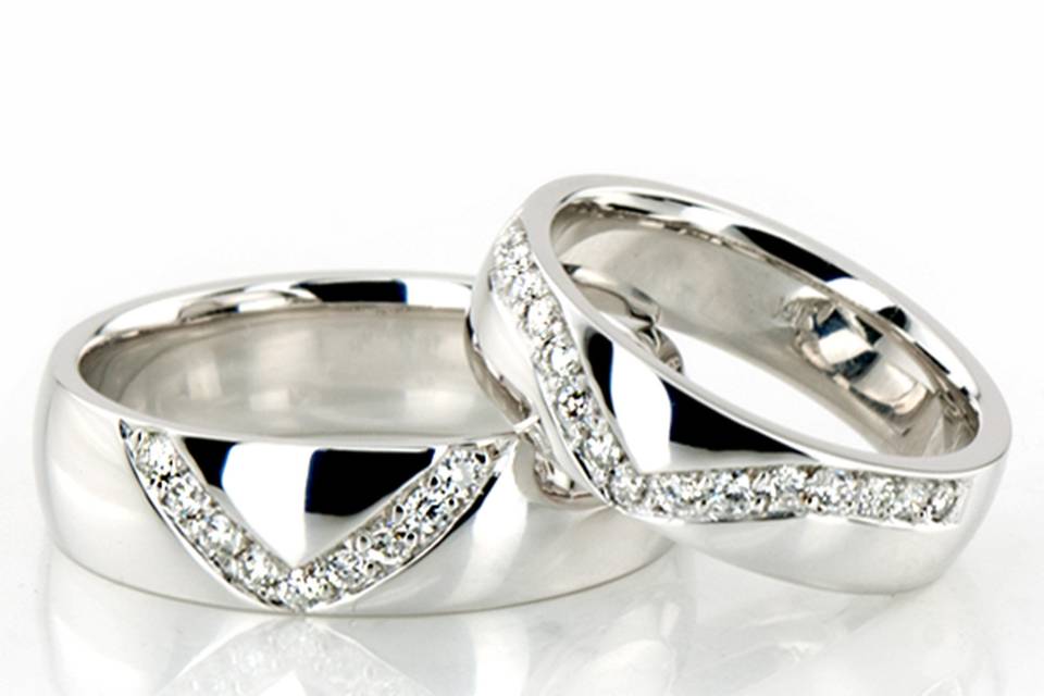 Lovely V shape channel set his & hers set. His ring is 6mm wide and set with 9 Round Brilliant Cut Diamonds. Each diamond weighs 0.015ct, total 0.135ct. Her ring is 5mm wide and set with 15 Round Brilliant Cut Diamonds. Each diamond weighs 0.015ct, total 0.225ct. The diamonds are graded G in color and SI1 in clarity. The band is high polished.