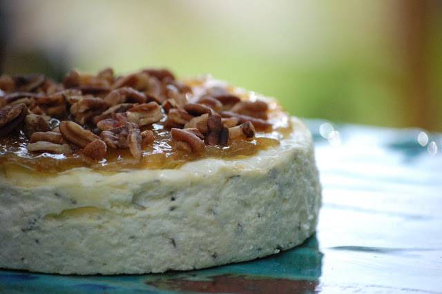 Blue cheese torte with pear preserves and pecans on top.