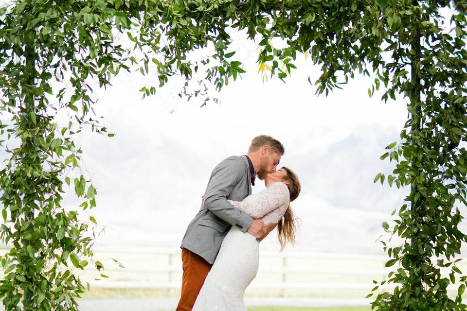 Wedding dress under green arch