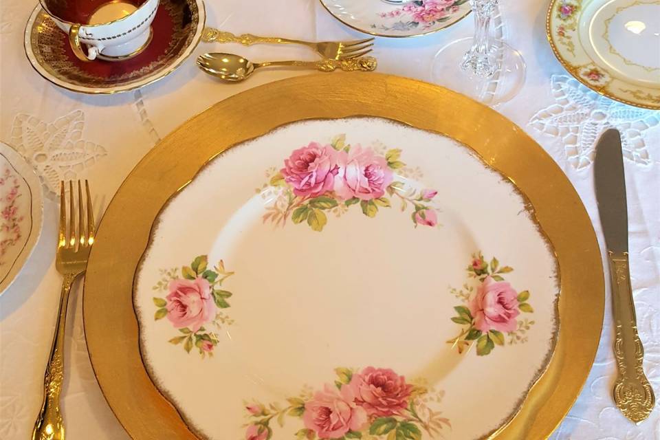 Vintage Dinner Plate, Silverware, vintage teacups, gold charger, and crystal stemware. Go to www.royaltablesettings.com today.