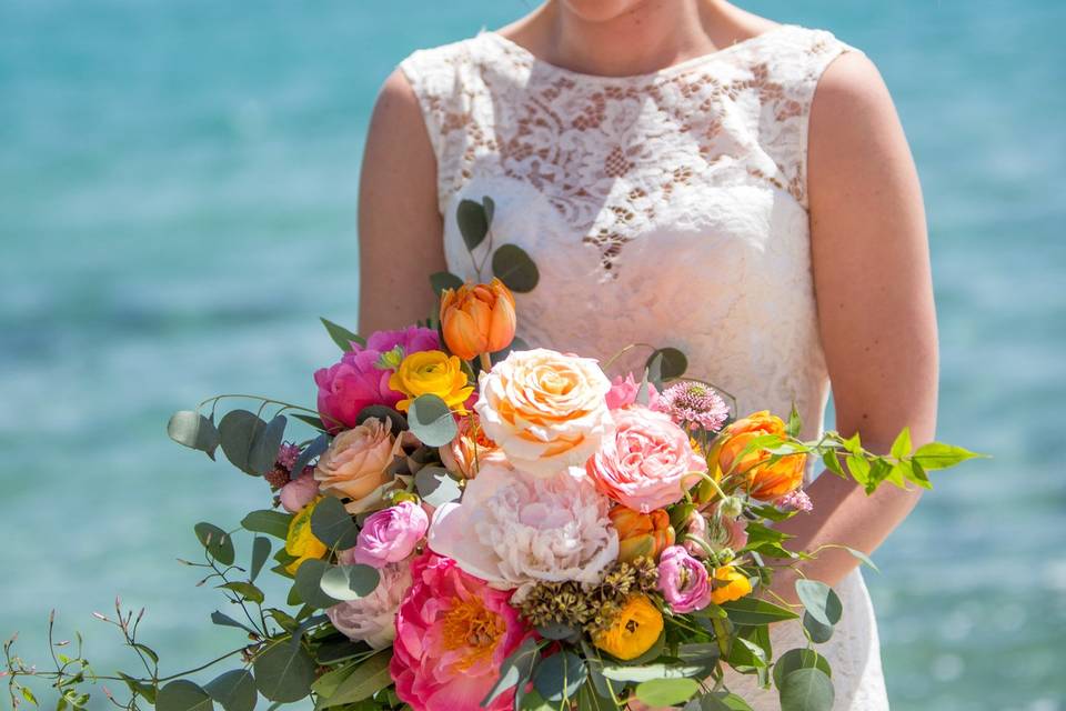 Bride holding her bouquet by the sea