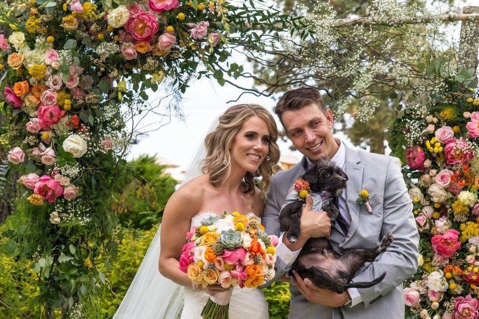 Bride and groom with their dog under the arch