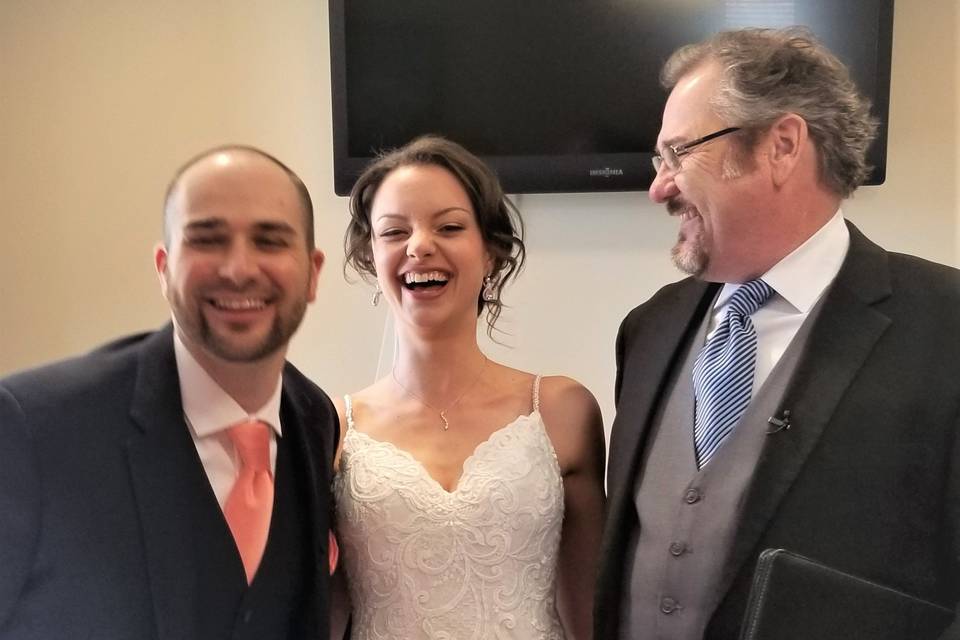 Smiling couple with officiant
