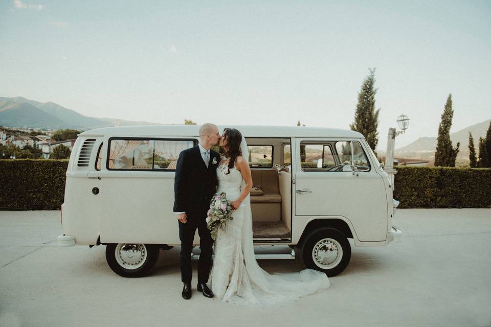 Happy couple with wedding van