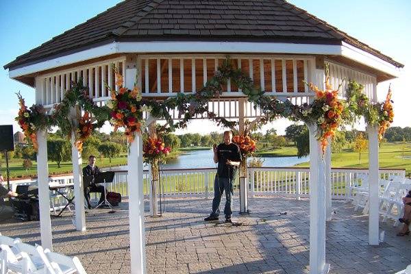 The gazebo at Palos Country Club, decorated with rich fall tone flowers and garland for an October wedding.