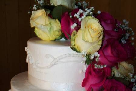 Floral details of Whimsical Flower Cake:  Three tiers of homemade fondant-covered french vanilla cake (raspberry cream filling), hand made fondant flowers, circles, and other details.