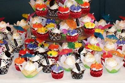 Tropical Hibiscus Wedding Cupcakes:
Tropical wedding theme: Black and white cupcakes on top symbolize the couple's bridal party colors. Three types of cupcakes: Coconut with coconut buttercream, garnished with toasted coconut and parasols
