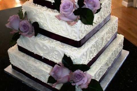 4 tiered buttercream with hand-piped scroll details and sterling roses