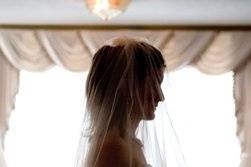 The bride paused to take one last look in the mirror before joining her father to walk down the aisle.  She was beatifully back lit and we were able to capture a wonder image.