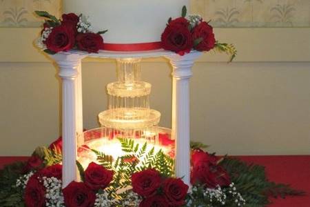 Fountain Wedding Cake at the Seafood Peddler Restaurant in San Rafael, CA.  Homemade fondant covered tiers of Carrot Cake and Cream Cheese filling, stacked on pillars and decorated with fresh roses, ferns, baby's breath and satin ribbon.  A lighted fountain bubbled below and sounded lovely!