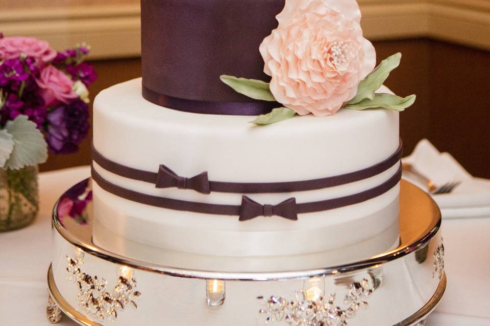 Three tiered, custom wedding cake designed by the bride and groom and made by Let's Do Cake! Hand cut silhouette of the bride and groom, large fantasy flower with a pearl stamen center and other details out of sugar paste.  Covered in fondant to match the bride's colors, and placed on our round silver cake pedestal.  We also made a cutting cake to serve additional guests.  Wedding was at The Vintner's Inn, Santa Rosa, CA.  Photo by Vero Suh Photography, San Francisco.