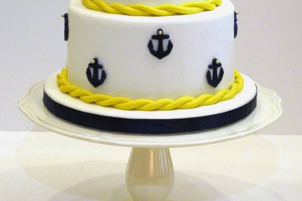 Nautical Wedding Cake covered in Home Made Fondant.  Handmade sugar paste Topper and Fondant Anchors and Rope Trim adorn this cake.  For a wedding at Bodega Bay Lodge.