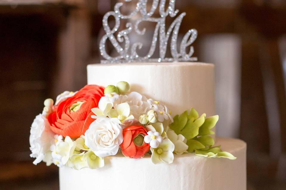 Smooth Italian Meringue Butter Cream frosted wedding cake with handmade sugar flowers.  Purchased topper by the bride.