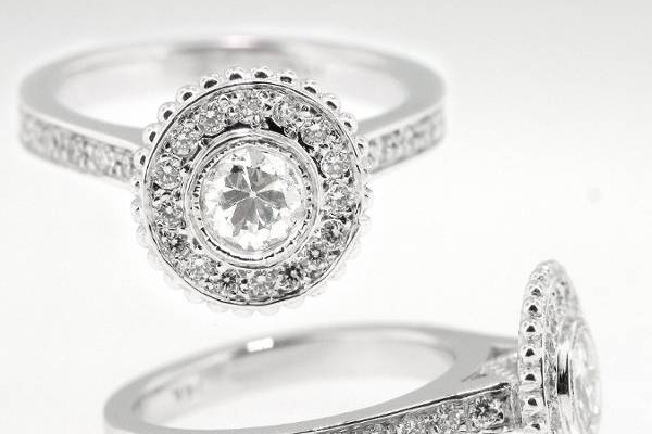 This Jill Lynn custom designed engagement ring features an old European cut diamond bezel set center stone and micro pave set diamonds will millgrain detail.