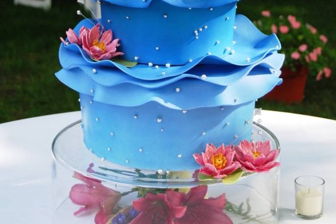 A summertime wedding cake representing water and sky, complete with Orion's Belt, the Big Dipper, and the couple's Zodiac Constellation, Cancer.  Not to mention a frosting replica of their beloved pup Gatsby swimming in the Milky Way!