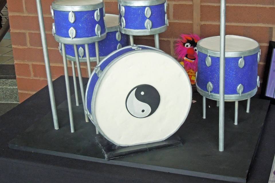 A cake that was a long time in the planning: the Groom was a drummer and wanted to showcase his passion, rather than display a traditional white wedding cake at the reception. So we designed a replica of his drum set complete with cymbals and the Muppet Animal in the background!