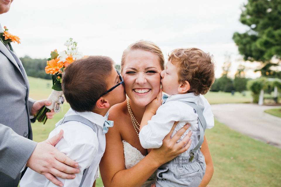 Children kissing the bride on the cheeks