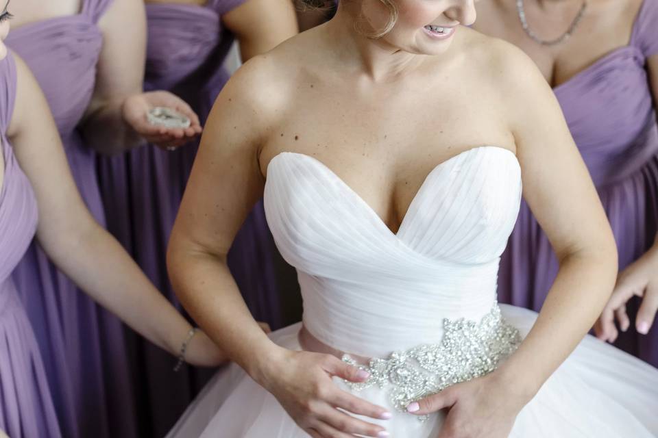 Bride putting on her dress