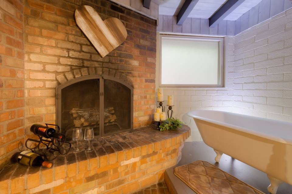 Clawfoot tub next to fireplace